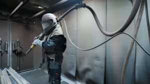 shot,blasting,man,in,production,,the,sandblaster,is,sending,to